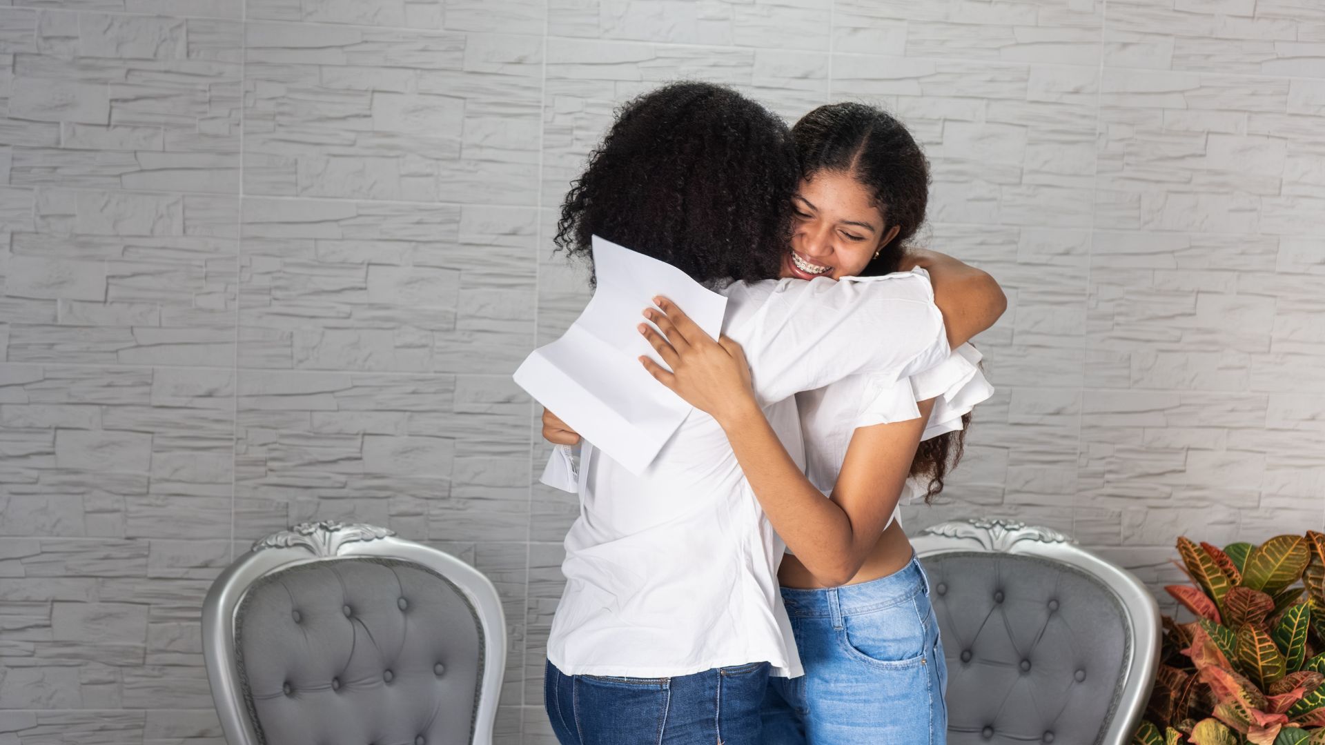 Mom and daughter hugging over college acceptance.